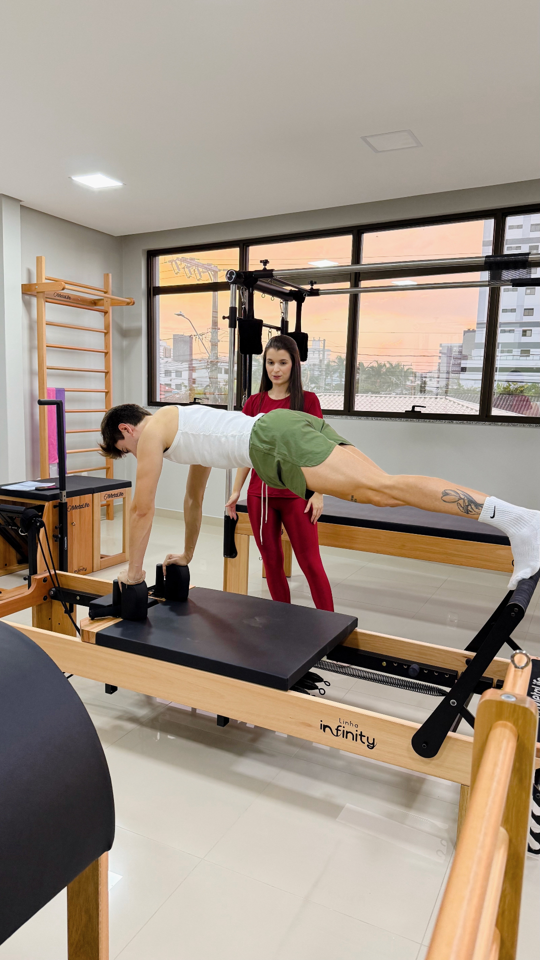 Aluno em prancha no reformer com acompanhamento
